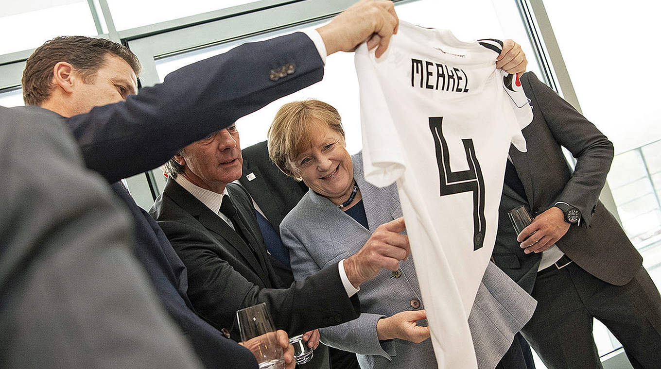 Gastgeschenk: Die Bundeskanzlerin erhält ein signiertes Trikot der "Mannschaft" © Bundesregierung/Guido Bergmann