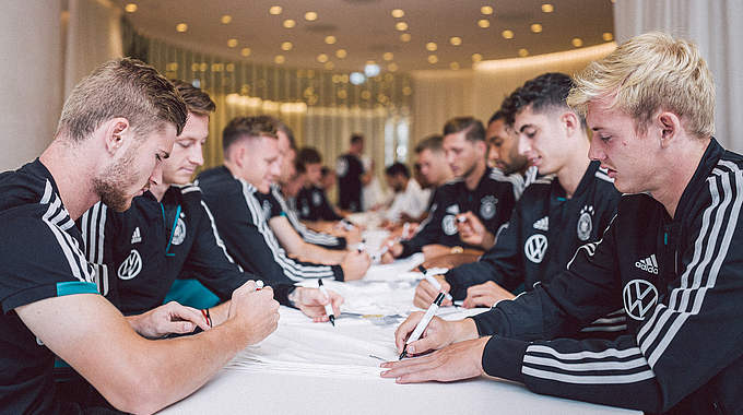 Am Tag nach dem Niederlande-Spiel stand für die Nationalmannschaft auch abseits des Platzes Fleißarbeit an. Bei einer Schreibstunde im Teamhotel wurden etliche Trikots signiert. Marcel Halstenberg und Niklas Stark kürten derweil die Sieger des Cup der Fans. © DFB | PHILIPPREINHARD.COM